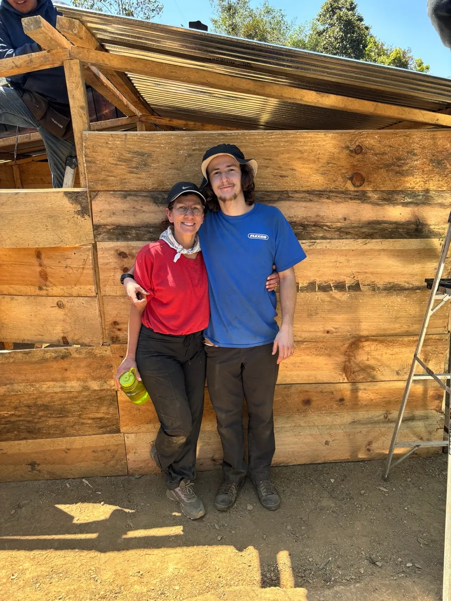 Grant Cooper with his mother in front of a house under construction during volunteer work in Guatemala.