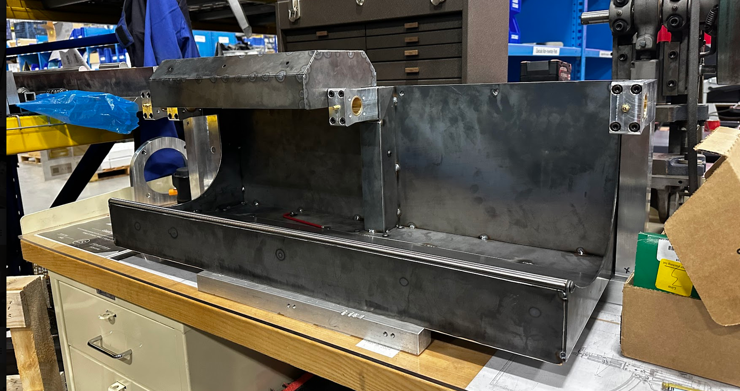 Rock Polisher assembly on a workshop bench, showing the steel guards, trough, and bearing blocks